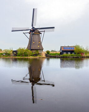 Very old traditional Dutch windmill supported by modern photovoltaic panels.