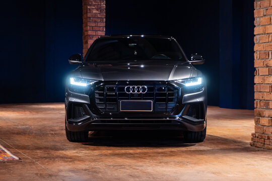 Grey Audi Q8 full centered front view in luxury garage, Luxury coupe SUV in dark cinematic studio