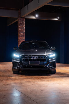 Grey Audi Q8 full centered front view in luxury garage, Luxury coupe SUV in dark cinematic studio