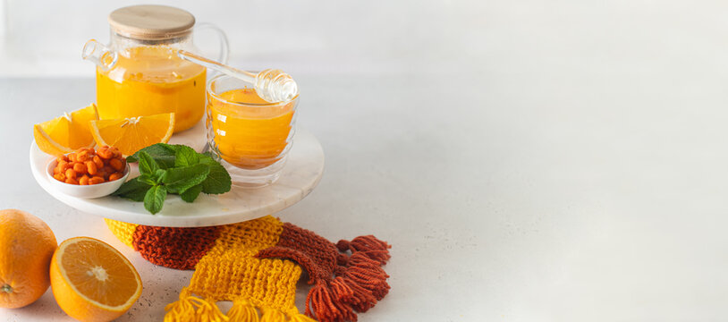 Sea buckthorn tea with orange and ginger banner on a table with knitted decor, suitable for beverage promotions and health-focused content, immune-boosting tea, sbiten