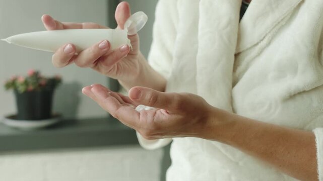 Skincare, wellness and treatment, hands hydration. Woman squeezes anti-aging moisturizing cream out of a tube and applies it to her hands