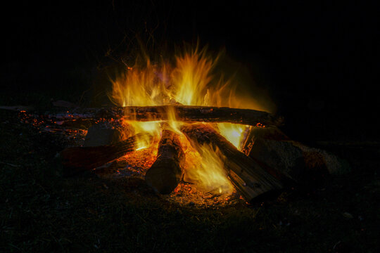 Beautiful image of camp and fireplace fire burning in the dark at night.