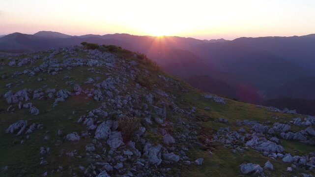四国カルスト姫鶴牧場の石灰岩群と妙見森などの山並みと夕日
