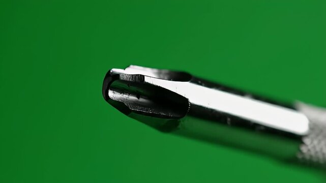 Macro Closeup Polished Phillips Crosshead Screwdriver Tip On Vibrant Green Background