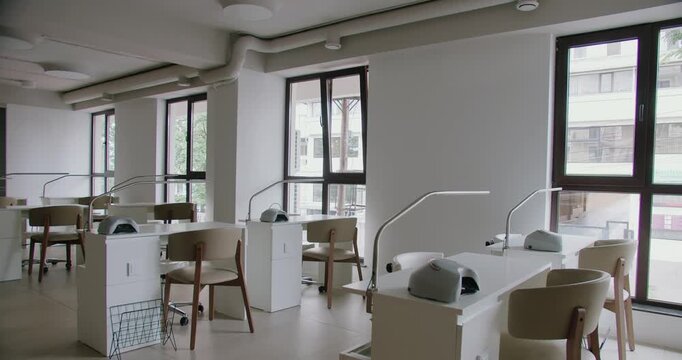 Contemporary nail salon showcasing clean, modern design with manicure stations and comfortable seating. Brightly lit and welcoming environment for beauty treatments.