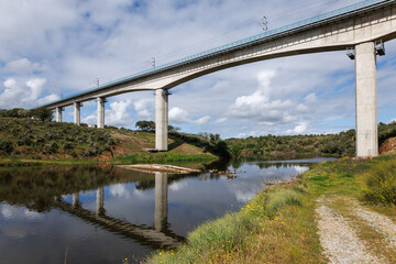 Fototapeta premium Modern railway bridge spanning river in rural alentejo portugal