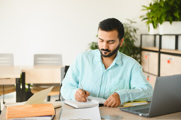 Fototapeta premium Indian student writing notes during college education class