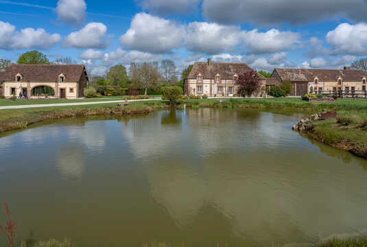 Charencey, France - 04 12 2026: Sky Background. A charming guest house in Le Perche region with a park, a pond, large trees and a blue cloudy and sunny sky