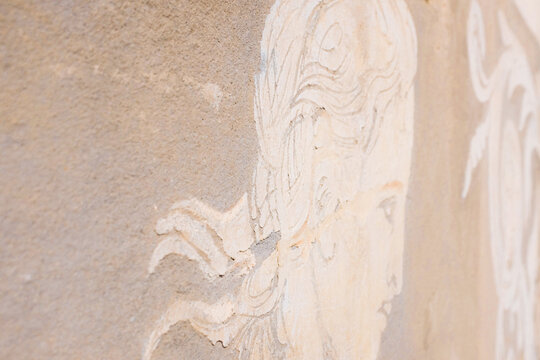 Pisa, Italy: Close-up of a historic sgraffito wall mural depicting a classical figure on a building facade in Piazza dei Cavalieri.