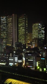 新宿のビル群と山手線と総武線の電車の夜景