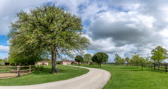 Charencey, France - 04 12 2026: Sky Background. A charming guest house in Le Perche region with a park, a pond, large trees and a blue cloudy and sunny sky