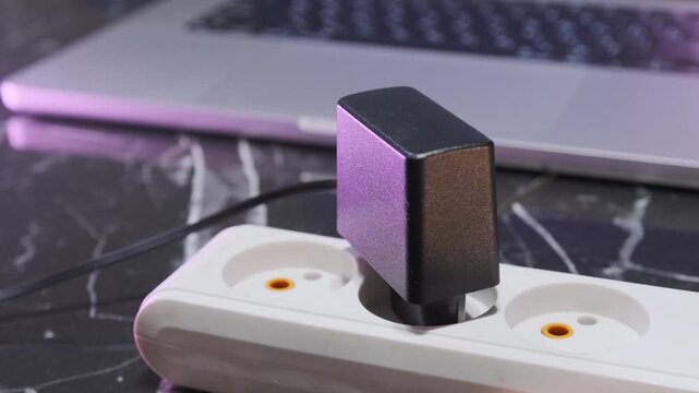 female hand plugging power adapter into electrical socket, connecting device to power supply, charging electronics at home, electricity and energy usage concept
