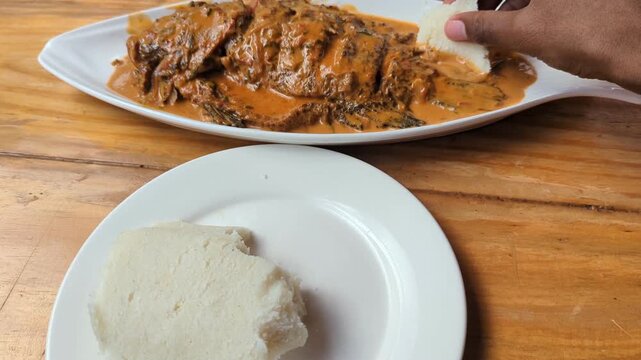 Ugali with Tilapia Coconut Fish Stew in Motion Video, Kenyan Cuisine Cornmeal Served with Creamy Fish Curry
