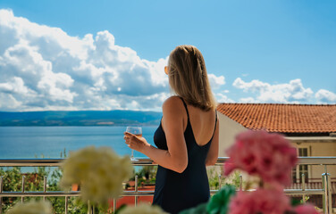 Obraz premium Woman admiring sea view from resort balcony.