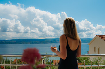 Obraz premium Woman admiring sea view from resort balcony.