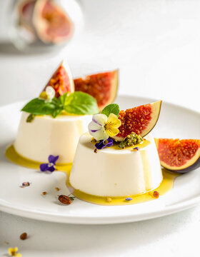 Elegant panna cotta desserts are plated with fresh figs, honey, basil, and edible flowers in a refined gourmet presentation.