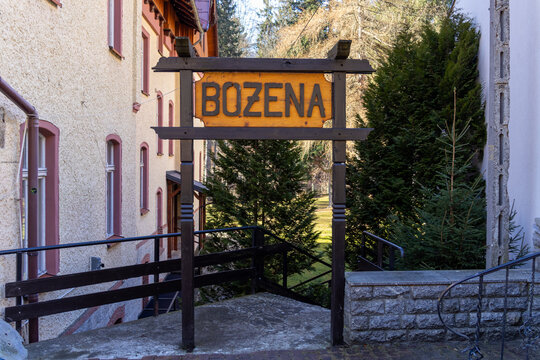 Szklarska Poreba, Poland - December 18, 2025: Bozena carved wooden sign, a rustic welcome to a historic guesthouse amidst lush green nature