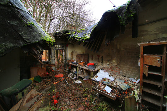 Abandoned workshop interior with collapsed roof debris and scattered tools