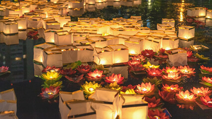 Lanterns floating on water, night festival with glowing lights, reflections, traditional celebration atmosphere, cultural event. Water lantern festival with light, spiritual ritual, night celebration © svetlanais