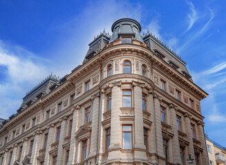 Fototapeta premium a majestic neoclassical corner building in Stockholm featuring ornate stone facades and a dark mansard roof.