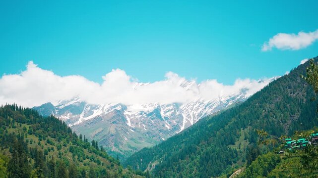 4K Landscape shot of clouds surrounding the snowy Himalayan mountain peaks during the summer season as seen from Manali in Kullu district, Himachal Pradesh, India. Scenic Landscape of Pir Panjal. 
