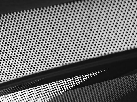 Perforated surface on car's glass window background