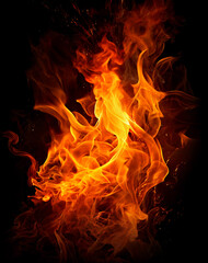 Fototapeta premium Blazing Inferno: A dramatic capture of swirling flames, a dance of vibrant orange and yellow hues against a dark background, embodies raw power and elemental energy.