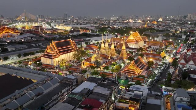 Bangkok, Thailand: Aerial night view of Wat Pho Thai Buddhist temple complex (Temple of the Reclining Buddha) in heart of Thai capital city, Grand Palace on horizon - landscape drone panorama
