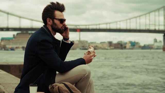 Businessman Talking On Smartphone While Eating Sandwich. Entrepreneur Multi-Tasking With Street Food 