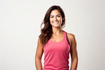 Fototapeta premium Smiling woman posing against a white background, wearing activewear