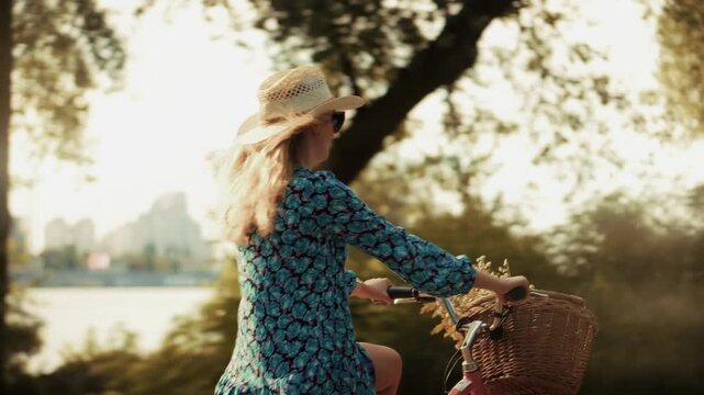 Traveler Enjoying Leisure Bike Ride In Nature. Young Woman Riding Retro Bicycle With Wicker Basket Through Autumn Park