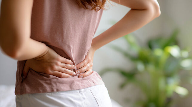 Chronic back pain prevention. Close-up of an unknown woman gently stretching the back at home.