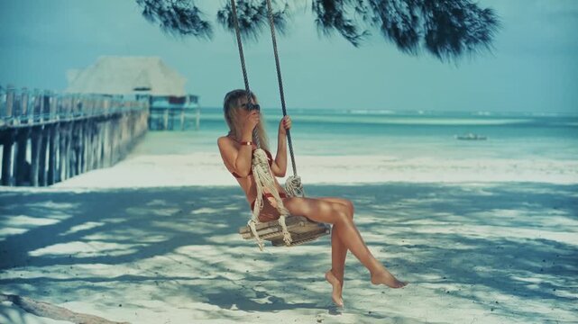 Traveler Swinging On Rope Swing At Tropical Beach. Resort Relaxation. Leisure Activity During Sea Voyage