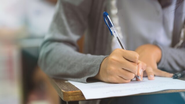 Close-up of Student Writing on OMR Answer Sheet in Final Exam