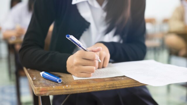 Close-up of Student Writing on OMR Answer Sheet in Final Exam