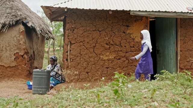 Rural African life highlighting water scarcity and daily water use. A woman washes dishes while a child carries water, emphasizing limited access, sustainability, and the vital importance of clean wat