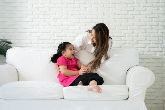 Caring Asian mother comforting and supporting her daughter with autism at home. Concept of neurodiversity, emotional regulation, and special education for children with developmental disabilities