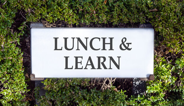 Lunch and learn symbol. Concept words Lunch and learn on beautiful big white sign plate. Beautiful green garden background. Business, educational and lunch and learn concept. Copy space.