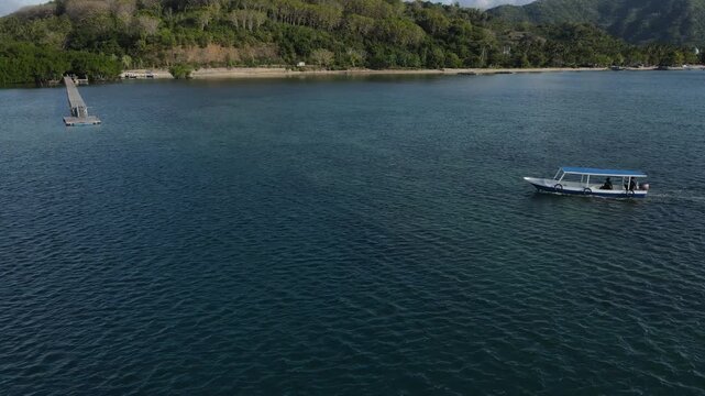 Drone tilt-down shot revealing turquoise sea and sandy shoreline in Sekotong.