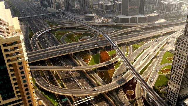 Stunning Aerial top view of highway junction with traffic in Dubai, UAE at sunset. Famous Sheikh Zayed road in Dubai downtown. 
