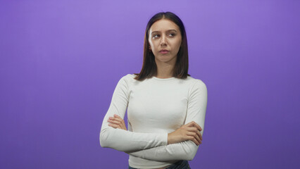 Obraz premium Woman arms crossed with visible hands in studio purple backdrop wearing white long sleeve shirt; disapproval assertiveness.