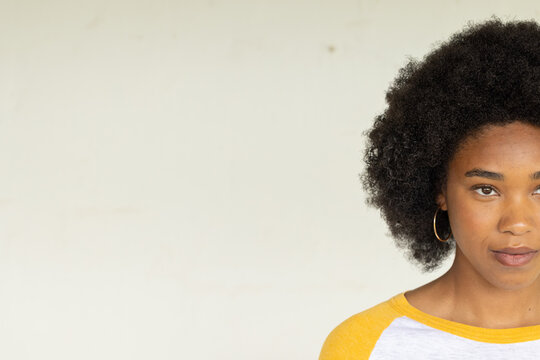 African American woman posing in studio on right wearing yellow shirt gold-hoop earring, copy space
