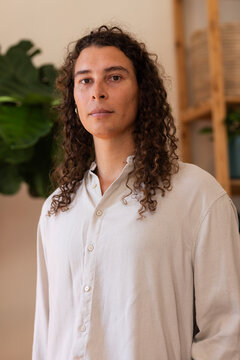 Nonbinary person posing in studio, shutter causing moving tags around person tagging plants for PR