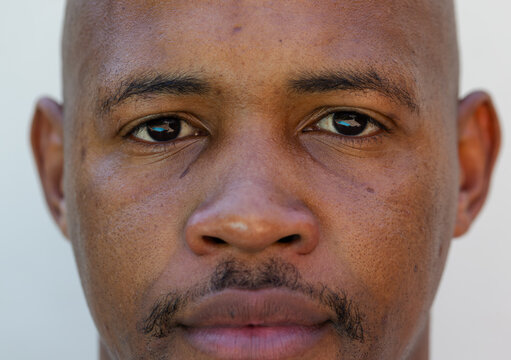 Close-up portrait capturing man looking directly at camera in studio with neutral backdrop