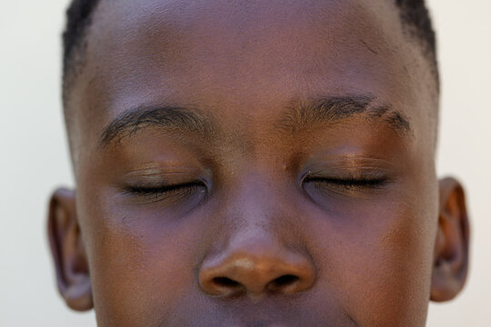 African adolescent male resting with eyes closed in studio close-up showing skin texture