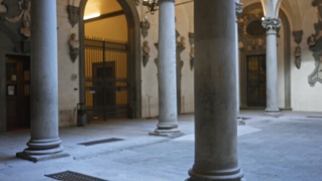 Defocused columned courtyard with stone arches and muted details interior; background backplate copyspace calm.