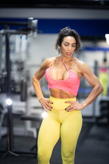 Fototapeta premium Strong athletic woman posing in modern gym