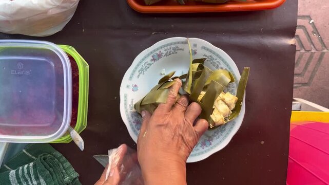 Traditional breakfast cuisine of West Sumatera street food, Ketupat Padang, sticky rice cake packed inside the coconut leaves