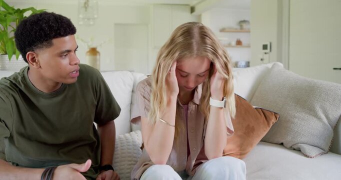 Woman covering face in distress when man reaching out, placing hand, leaning in, calming partner