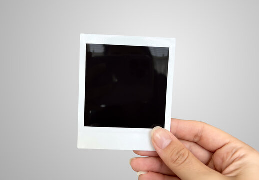 Instant photo in clean woman&rsquo;s hand Isolated on grey background Mockup. Generative ai